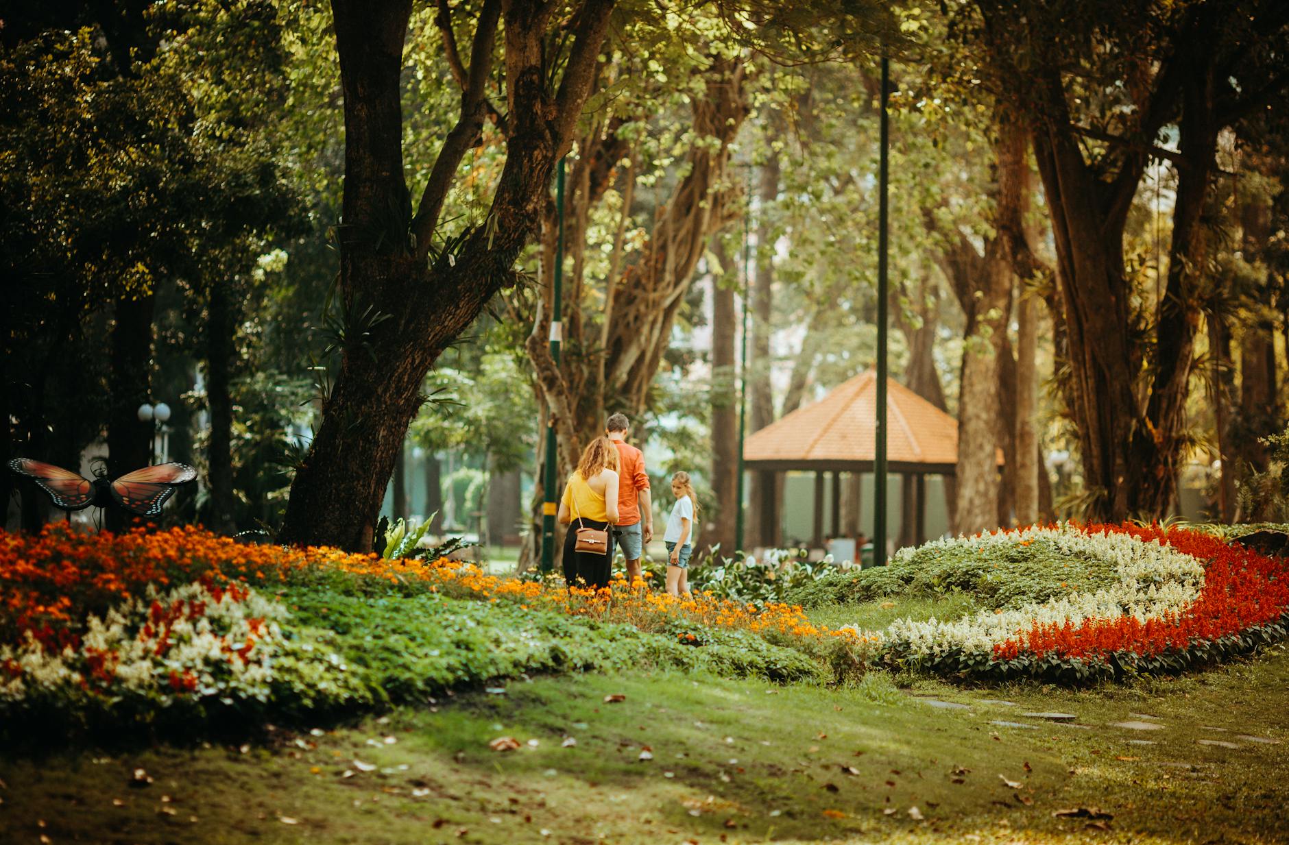 Family walking through botanical garden with lush green plants and trees