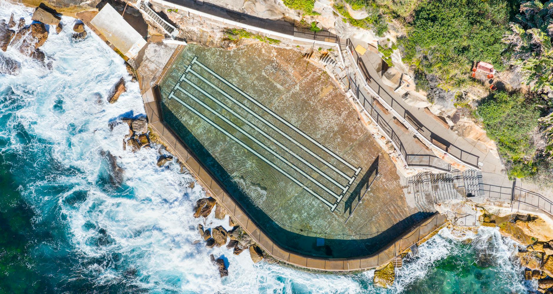 Sydney beaches - Bronte Beach rock pool with ocean waves and coastal cliffs