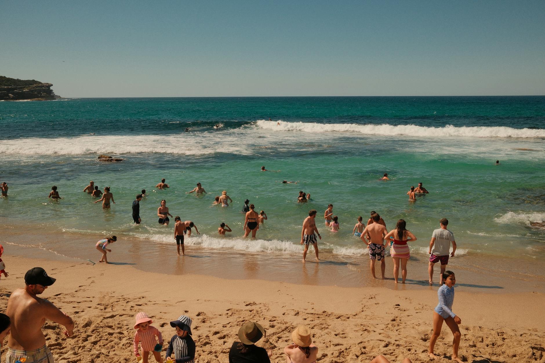 Family enjoying a day at a Sydney beach with children playing in the sand