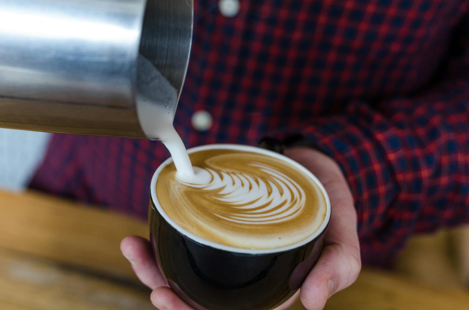 Best restaurants in Sydney - barista preparing a perfectly crafted flat white coffee with latte art