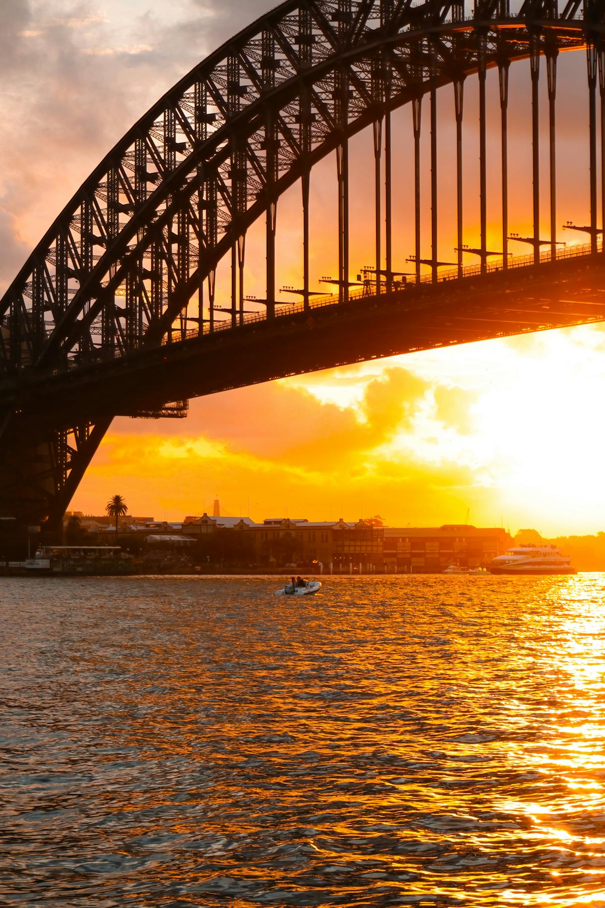 Sydney Harbour Bridge silhouetted against a golden sunset