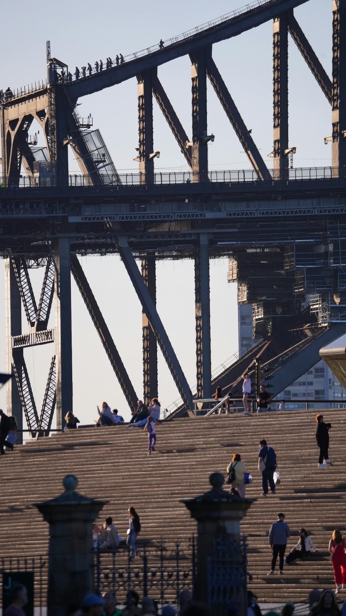 Pedestrians walking across Sydney Harbour Bridge walkway