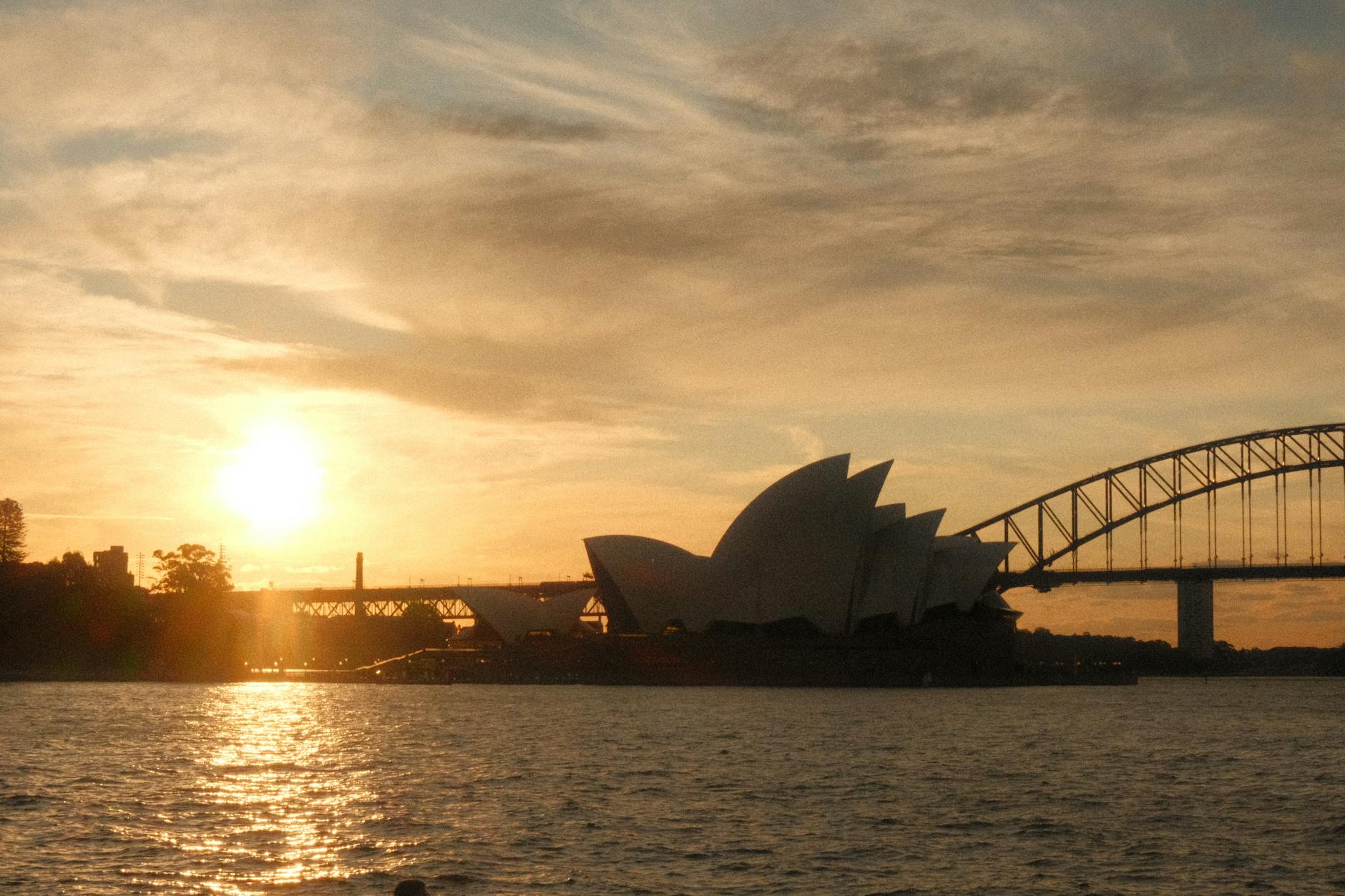 Best time to visit Sydney - Stunning sunset behind the Sydney Opera House showcasing ideal evening weather.