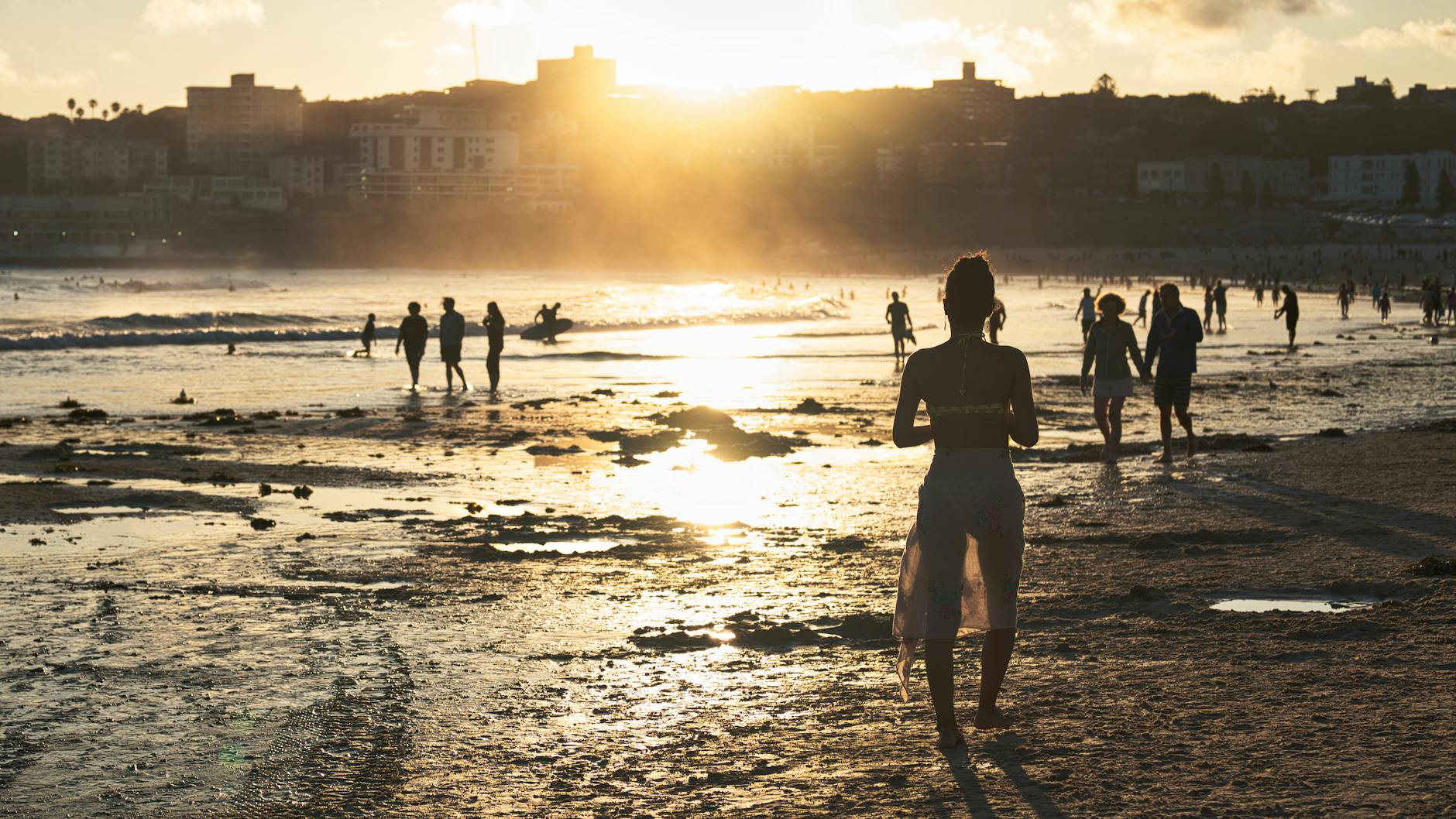 Surfing in Sydney - surfer riding wave at Bondi Beach with golden sand