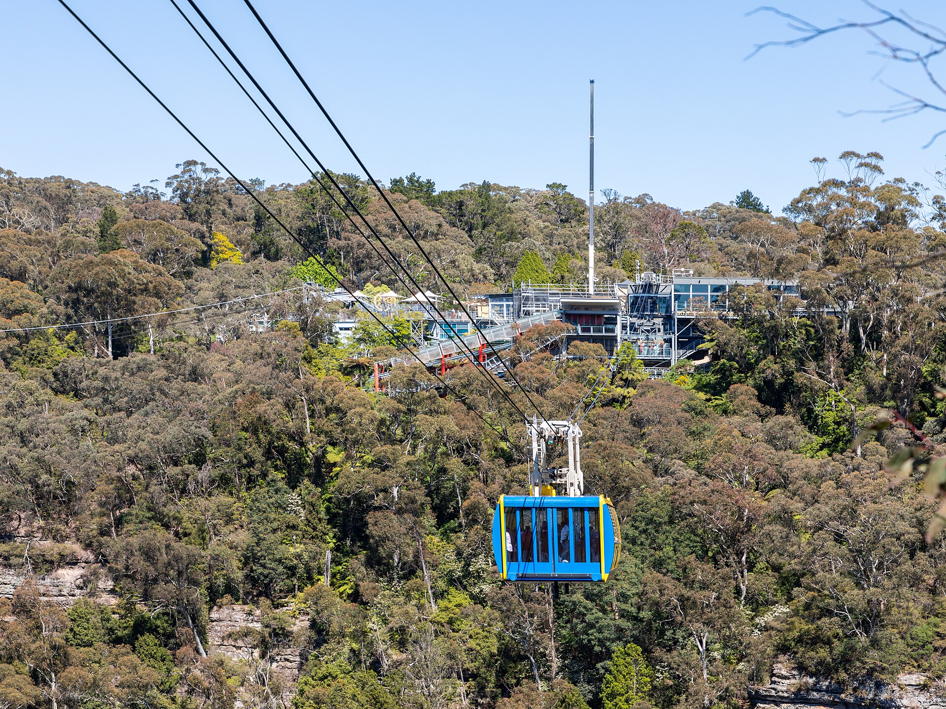 The blue and yellow Scenic Skyway cable car crossing the gorge with the Scenic World terminal behind